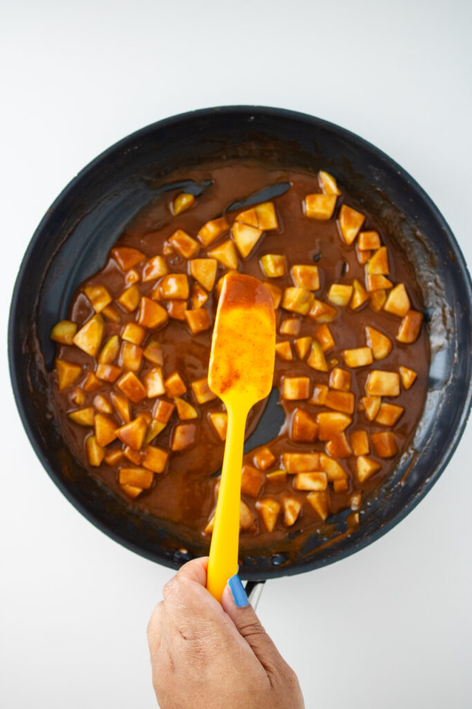 large pan on white background holding cooked apples for the apple fritter focaccia