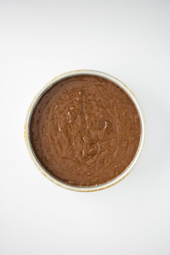 Chocolate cake batter in an eight-inch round cake pan