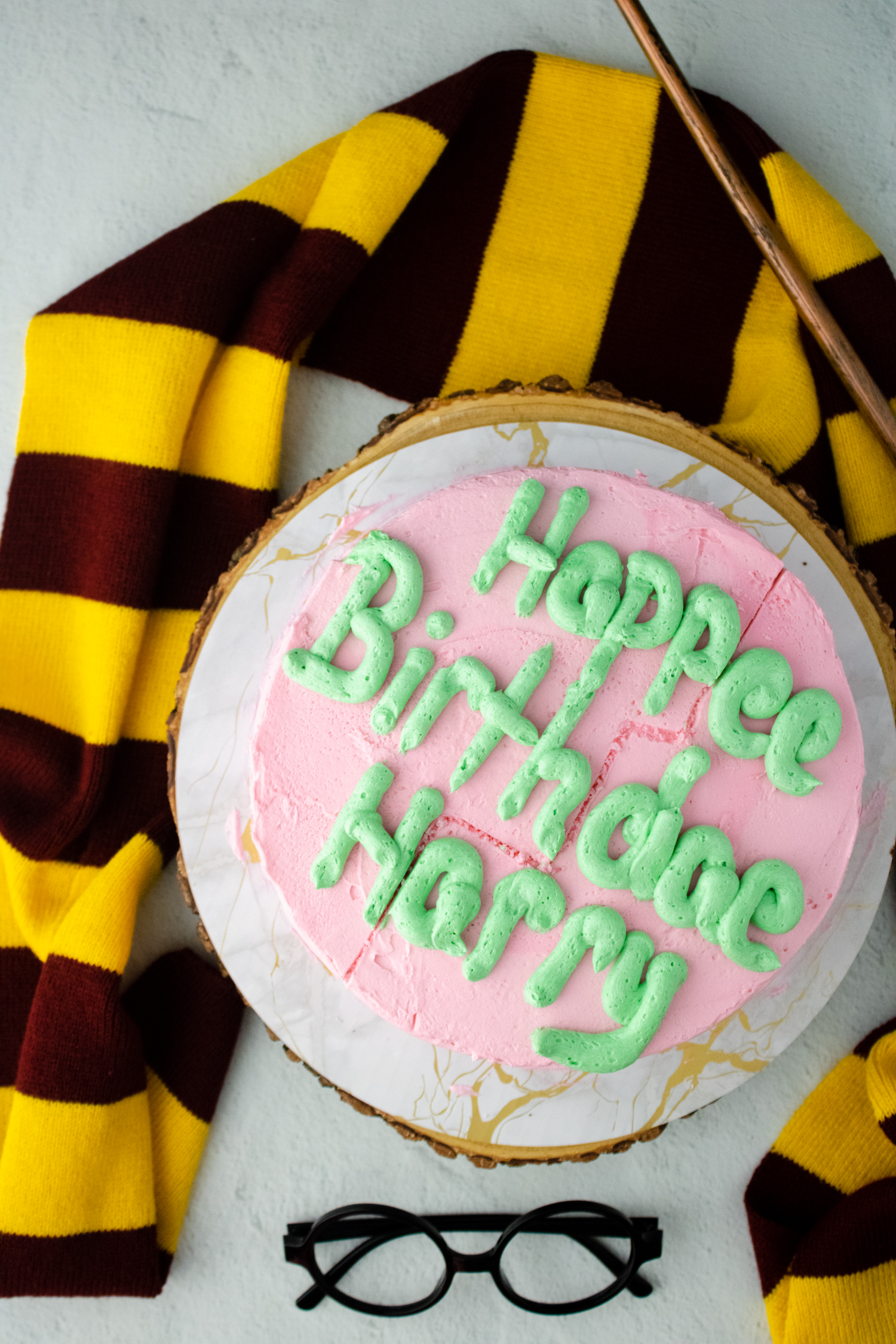 Finished pink Hagrid-inspired birthday cake with green lettering