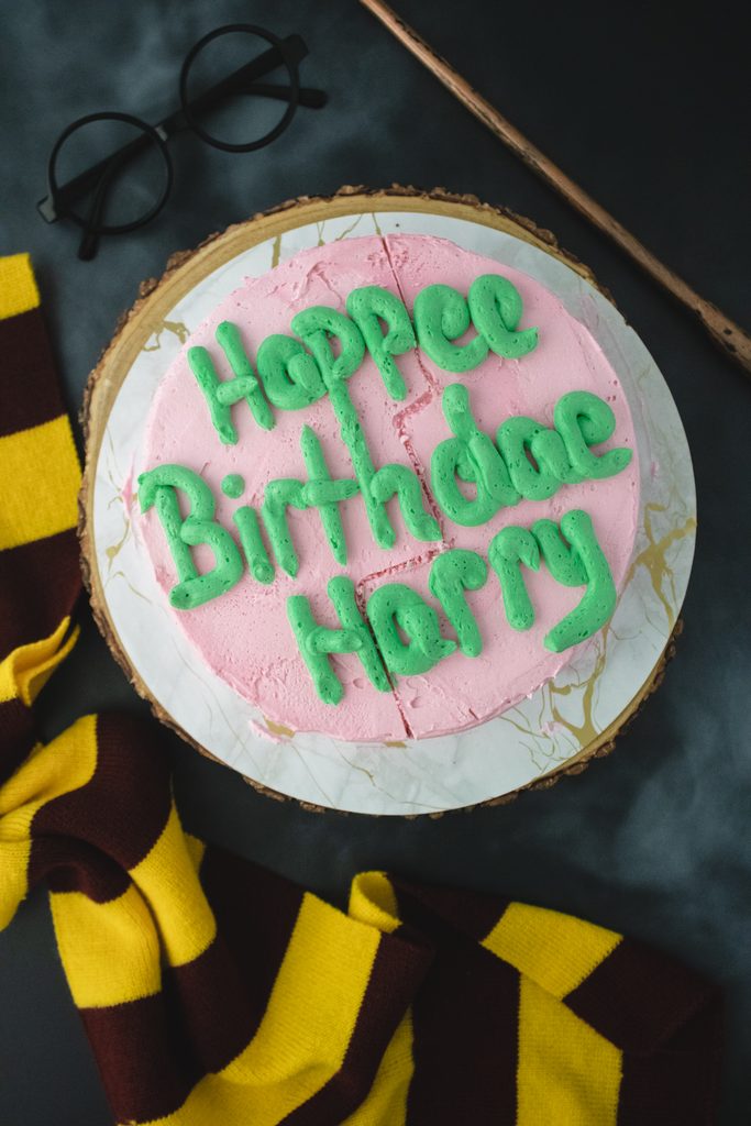 Finished pink Hagrid-inspired birthday cake with green lettering