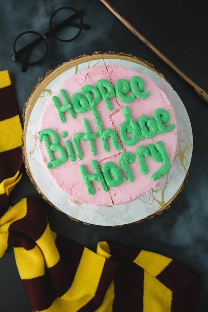 Hagrid-inspired Harry Potter birthday cake with pink frosting and green lettering